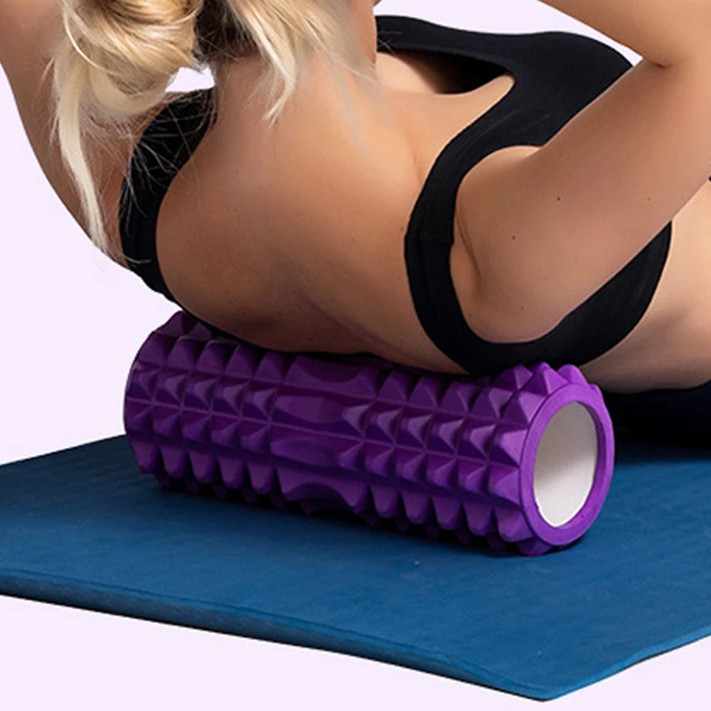 Woman using a purple foam roller for upper back massage